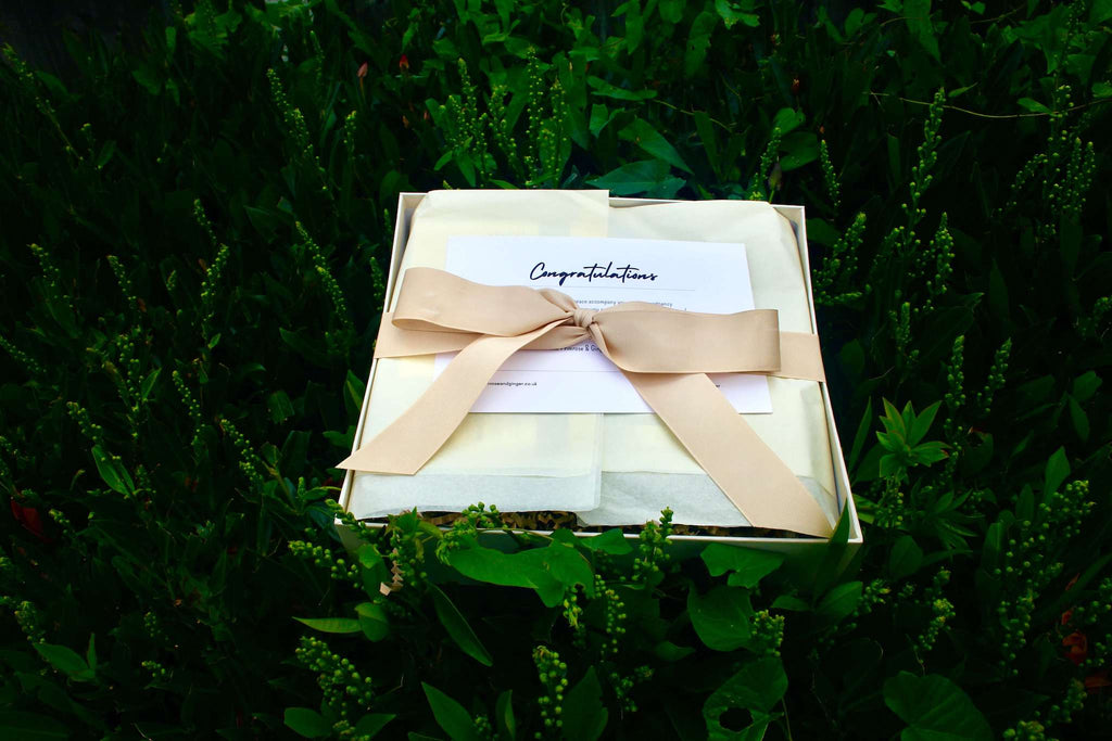Luxury postpartum wellness gift box wrapped with ribbon for new mothers