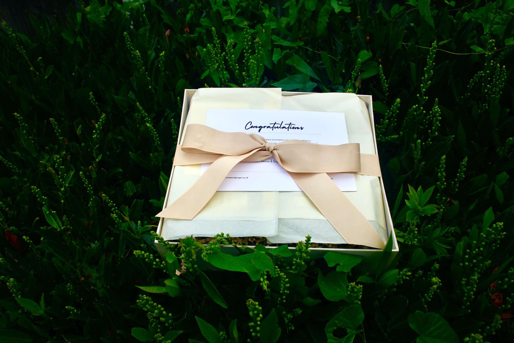 Luxury postpartum wellness gift box wrapped with ribbon for new mothers
