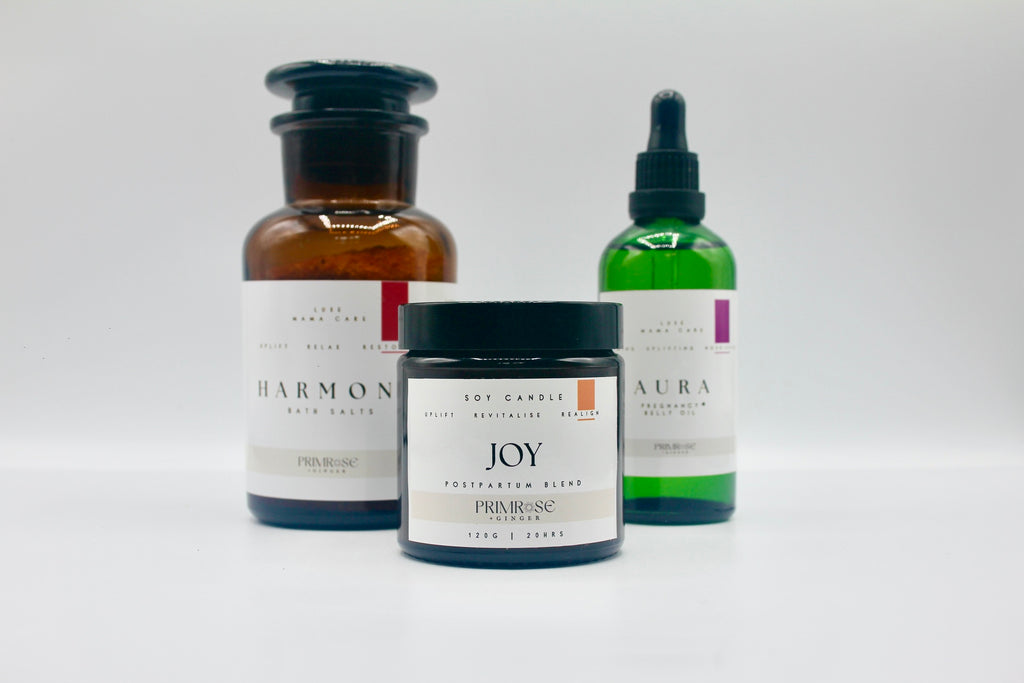 Minimal postpartum wellness products including bath salts candle and essential oils